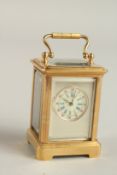 A MINI GILT AND SILVER FACED CARRIAGE CLOCK. 6cms high.
