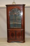 A GEORGE III MAHOGANY STANDING CORNER CABINET with a pendant moulded cornice, octagonal glazed