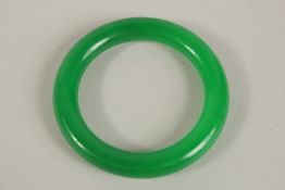 AN APPLE GREEN JADE BANGLE. 8.5cms diameter.