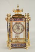 A GOOD REPLICA LOUIS XVI GILT METAL AND CLOISONNE ENAMEL CLOCK with urn finial and six columns.