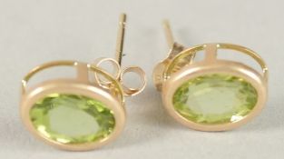 A PAIR OF 9CT GOLD PERIDOT EARRINGS.