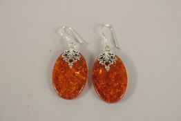A PAIR OF AMBER AND SILVER EARRINGS.