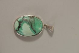 A SILVER HARDSTONE PENDANT.