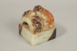 A CHINESE CARVED WHITE JADE SEAL, carved with dragons. 9cms.