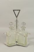 A GOOD SILVER PLATE THREE BOTTLE STAND with whisky decanters and stoppers.