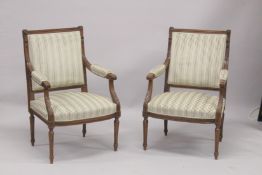A GOOD PAIR OF FRENCH BEECHWOOD ARMCHAIRS with padded seats, backs and arms, on turned legs.