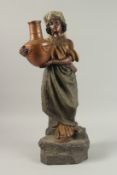 A GOLD SHIELD POTTERY ARAB WOMAN carrying a pitcher. 60cm high.