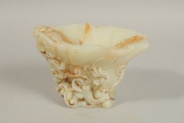 A CHINESE CARVED WHITE JADE LIBATION CUP. 10cms high.