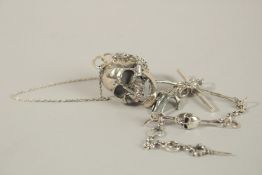 A SILVER SKULL ON A CHAIN.