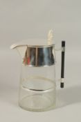 A CHRISTOPHER DRESSER DESIGN GLASS AND SILVER PLATE CLARET - LEMONADE JUG with ebony handle. 22cms