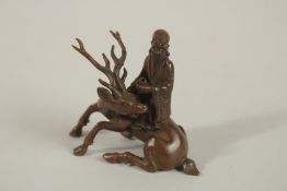 A CHINESE BRONZE MAN WITH A DEER. 7cms high.