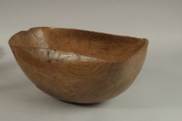 AN EARLY UNUSUAL SHAPED PLAIN WOODEN BOWL. 33cms long x 15cms deep.