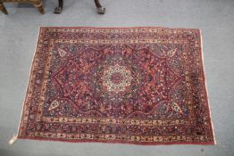 A PERSIAN CARPET, dark blue ground, with all over stylised floral decoration. 202cms x 139cms.