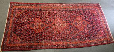 A PERSIAN CARPET, blue ground with stylised floral decoration. 310cms x 138cms.