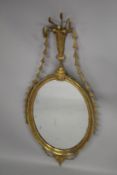 A GOOD GEORGE III ADAM DESIGN GILTWOOD OVAL WALL MIRROR with urn, wheatsheaf and harebell