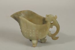 A CHINESE CARVED JADE OR GREEN HARDSTONE RITUAL JUG, with carved chilong handle and tripod legs,