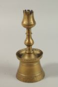 A 17TH CENTURY OTTOMAN TURKISH BRASS TULIP SHAPE CANDLESTICK, 24cm high.