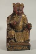 A 19TH CENTURY OR EARLIER CHINESE CARVED AND LACQUERED HARDWOOD THRONED EMPEROR, 31cm high.