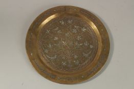 AN ISLAMIC SILVER AND COPPER INLAID BRASS TRAY, 32.5cm diameter.
