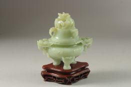 A FINE CARVED JADE LIDDED TWIN HANDLE KORO, on a fitted hardwood stand, with carved dragon and