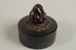A FINE 19TH CENTURY CIRCULAR JEWELLERY BOX WITH CHERRY AMBER FINIAL, the lid with metal mount with