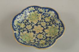 A CHINESE BLUE GROUND FAMILLE VERTE PORCELAIN PETAL FORM DISH, with lotus designs, the base with