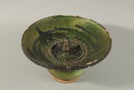 A RARE 17TH-18TH CENTURY PERSIAN SAFAVID GREEN GLAZED POTTERY WASHING BASIN, 29cm diameter.