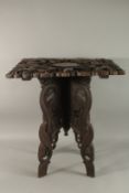 A 20TH CENTURY THAI CARVED WOOD SQUARE-TOP TABLE, with relief dragon designs and carved folding