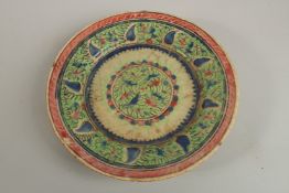 AN EARLY PERSIAN GLAZED POTTERY DISH, painted with foliate designs, 19cm diameter.