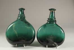 A PAIR OF 17TH CENTURY PERSIAN SAFAVID GREEN GLASS SADDLE FLASKS, largest 22cm high.