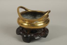 AN 18TH-19TH CENTURY CHINESE GILT BRONZE CENSER ON HARDWOOD STAND, with character mark to base,