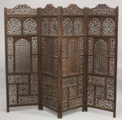 A FINE INDIAN CARVED SANDALWOOD OPENWORKED FOUR PANEL SCREEN, with carved birds and foliate designs,