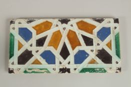 A FINE 17TH CENTURY SPANISH SEVILLE GLAZED POTTERY TILE, with geometric design, 28cm x 14cm.