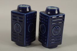 A PAIR OF CHINESE BLUE GLAZED PORCELAIN SQUARE FORM VASES, with carved yin yang symbols, 18cm high.