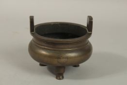 A CHINESE BRONZE TWIN HANDLE TRIPOD CENSER, with longevity symbols, 12cm wide.