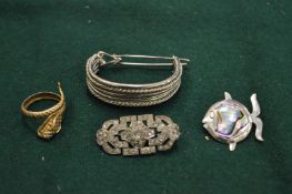 A silver fish brooch and other items.
