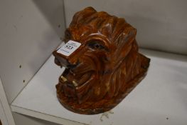 A carved wood lions head shaped cigarette dispenser.