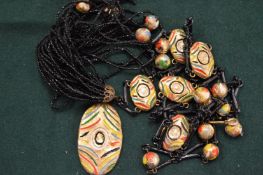 A black bead necklace with enamel decoration.