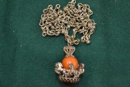 A silver chain and coral pendant.