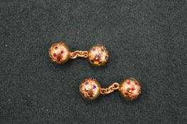 A pair of yellow metal and gem set ball shaped cufflinks.
