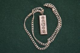 A silver ingot pendant and chain.