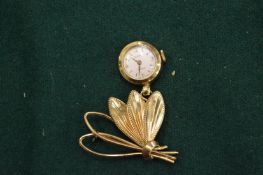 A watch brooch.