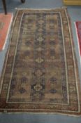 A Persian rug, worn, 192cm x 110cm.