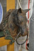 A pair of painted cast iron horse head wall mounted tethers.