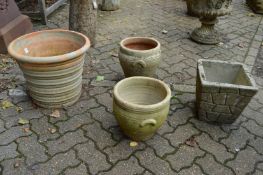 A large terracotta pot and three other plant pots.