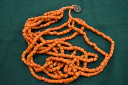 A large African coral necklace with inset coin.