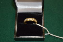 A yellow metal and white stone eternity style ring.