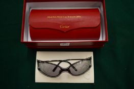 A pair of Cartier sunglasses, boxed.