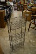 A wrought iron three tier rack.