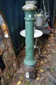 A green painted cast iron bollard.